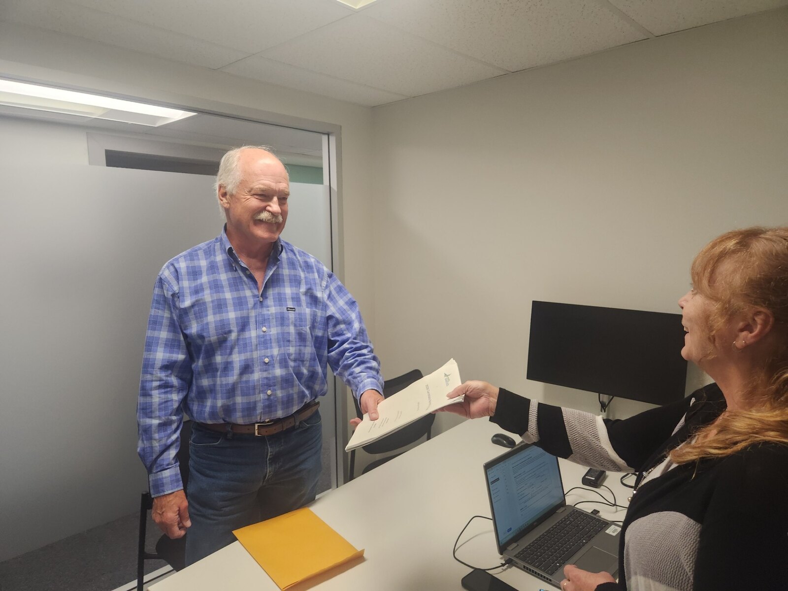 Jack McClintock presenting his nomination papers to District election staff